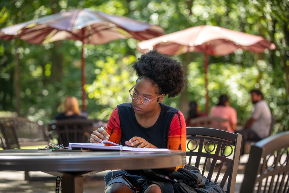 english student writing outside